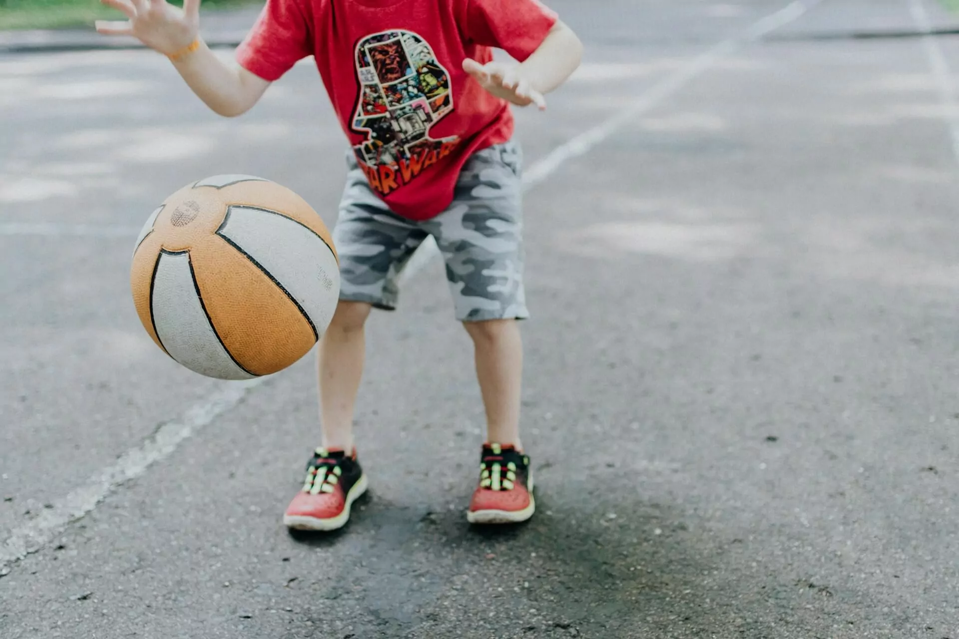 Ett barn som spelar basket, en av många fritidsaktiviteter för barn.